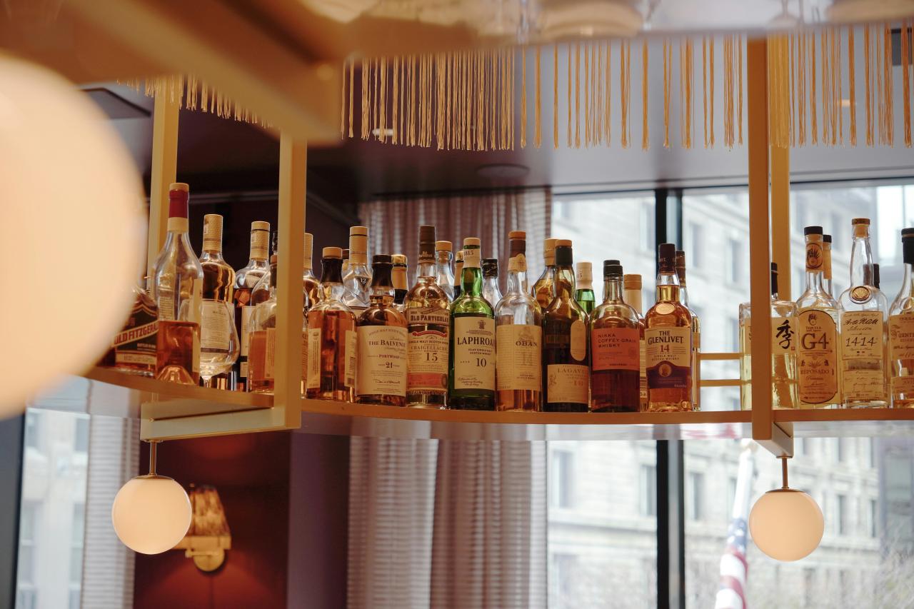Bar shelves are filled with various liquor bottles.
