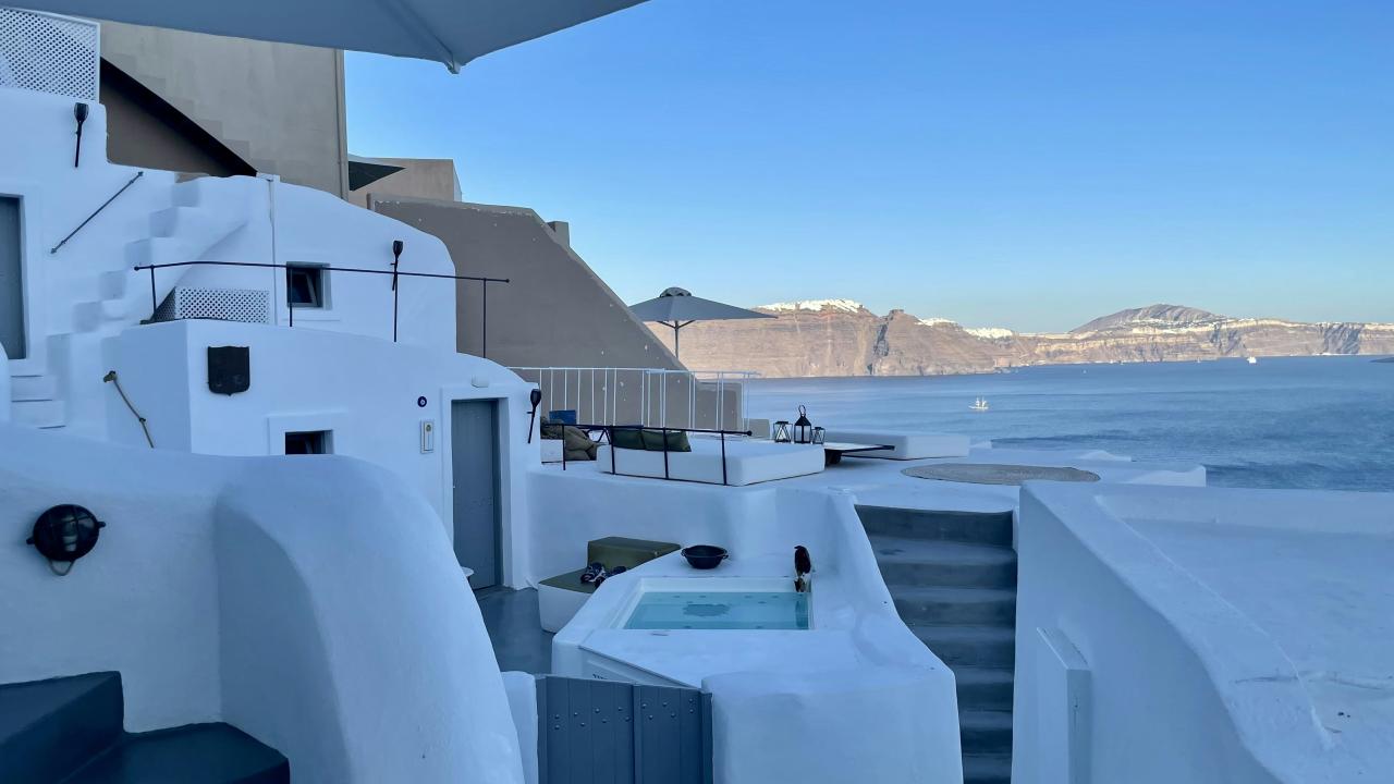 a hot tub sitting on the side of a building next to a body of water